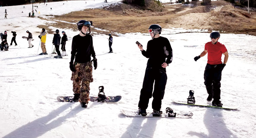 愛德華茲(Bevin Edwards)（右）和兒子菲尼克斯(Phoenix Edwards)（中）站在大熊山度假村的一條滑雪道底部。洛杉磯時報