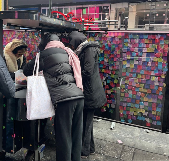 人們在許願牆邊寫下心願。