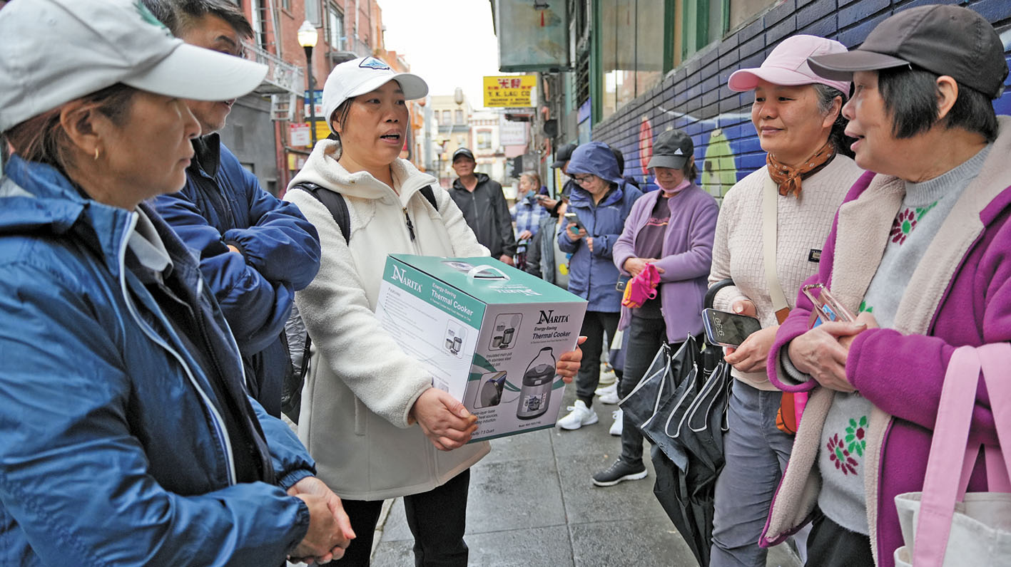 喜獲節日禮物的居民，與排隊輪候的居民分享喜悅。記者黃偉江攝