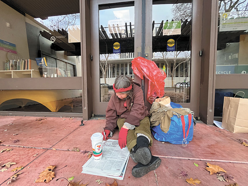 無家者Naomi坐在波羅阿多市市中心圖書館的大門前等待過夜取暖處開門。記者王蔚攝