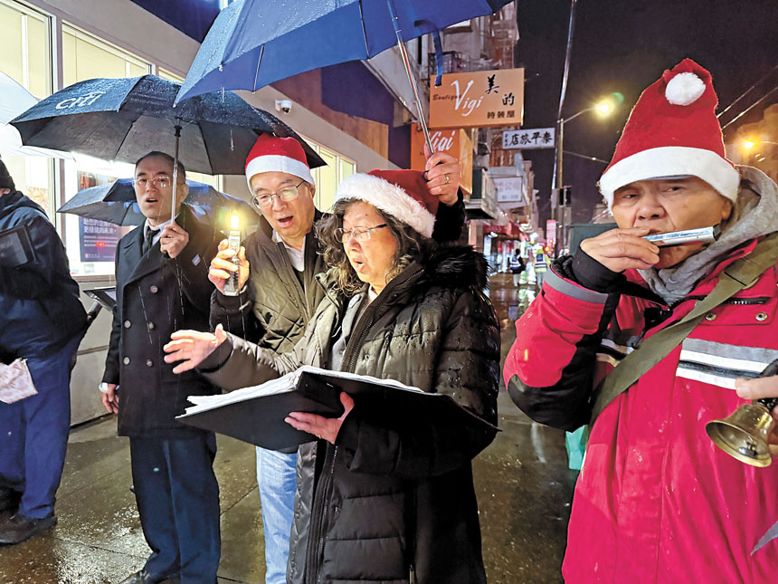 救世軍華埠堂及其他教堂的教友，頂著風雨，高唱聖歌。記者黃偉江攝