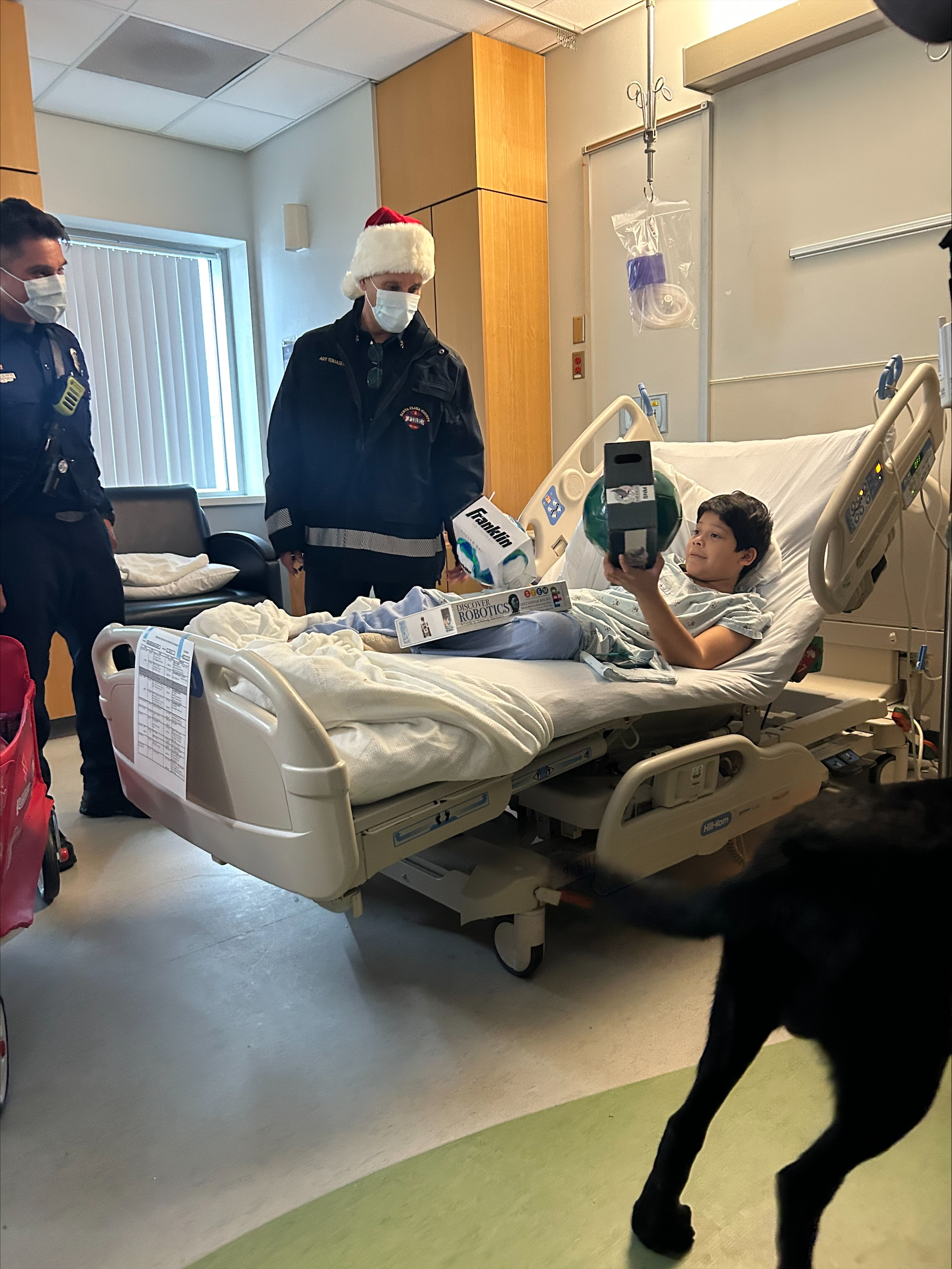 警員將禮物送到病房內小病人的手上。