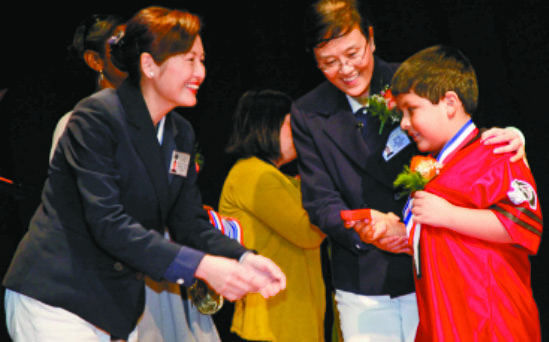 2012年2月4日，郭美玲（左一）和黃淑雲（右二）為學生頒發全勤獎。慈濟舊金山支會提供