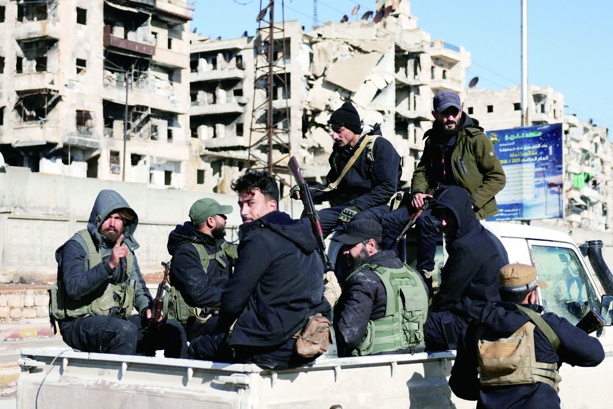 敘利亞政府軍表示,已在阿勒頗希克馬述區完成「安全掃蕩」。圖為政府軍坐在車上經過該地區。路透社