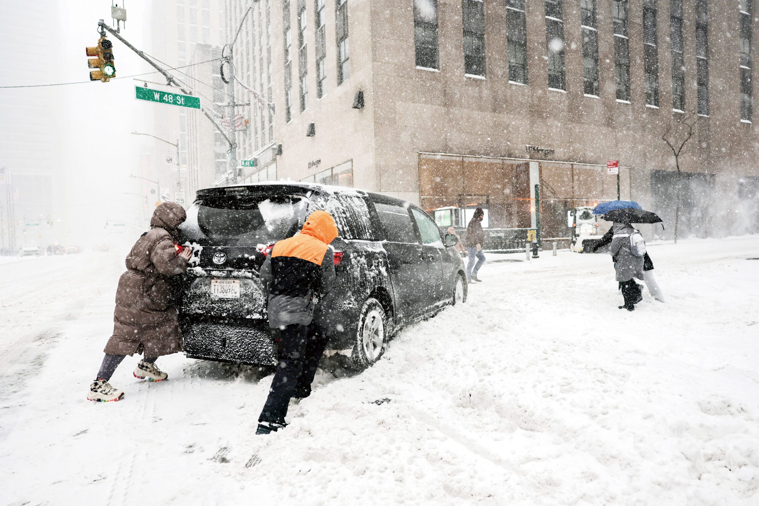 人們在時代廣場附近幫忙救助被困的車輛。路透社