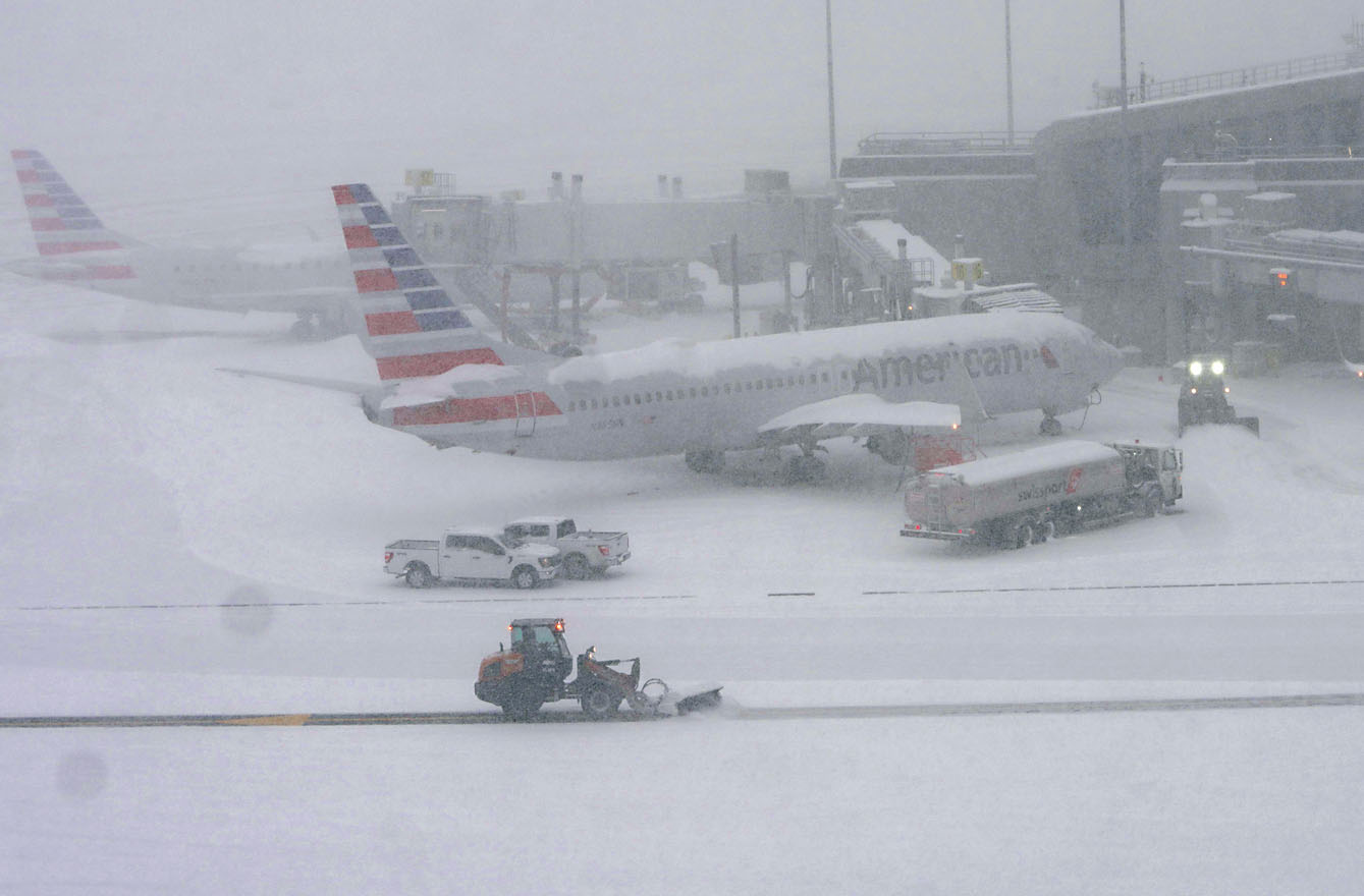 鏟雪車在紐約拉瓜迪亞機場清理積雪。新華社 .c5/c6 紐約工人奮力清理街道積雪。路透社