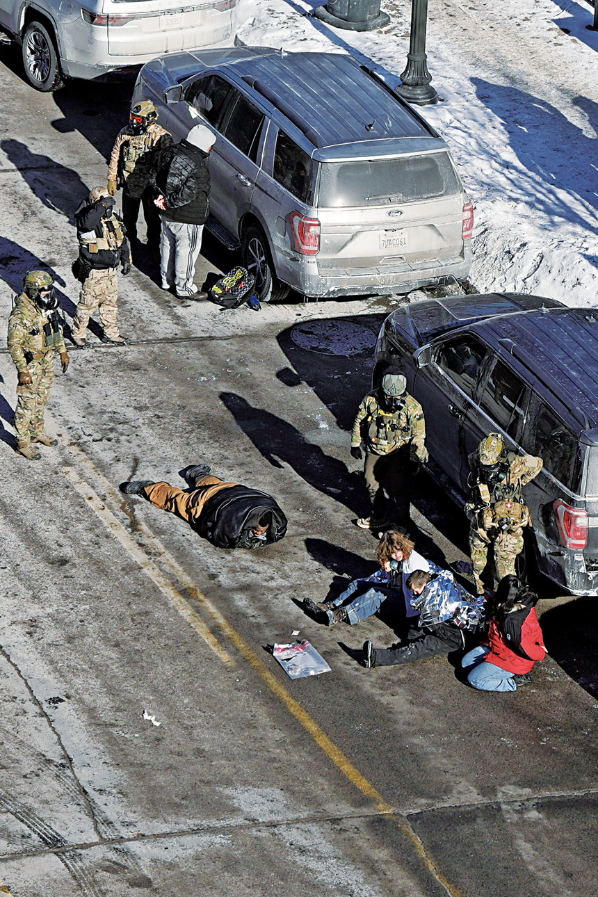 聯邦特工在槍擊現場拘留相關人員。路透社