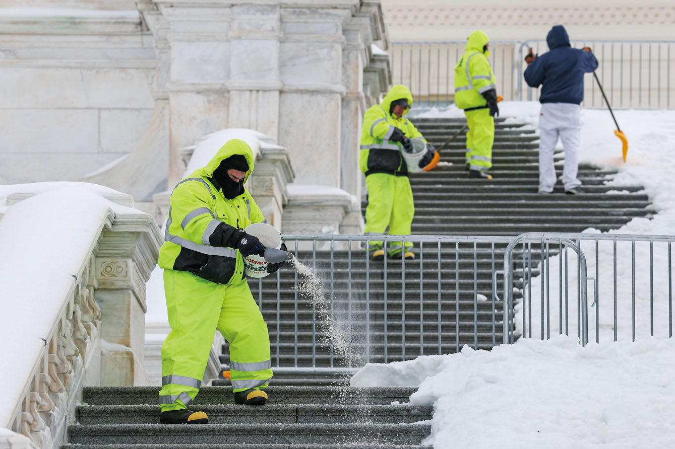工人們清除國會大廈台階上的冰雪。路透社