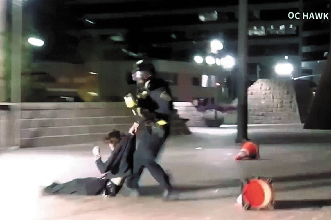 OC Hawk提供影片截圖顯示，1月9日在橙縣聖他安娜示威期間，一名聯邦執法人員拖拽一名面部遭執法人員近距離發射投射物擊中的示威者。OC Hawk/美聯社