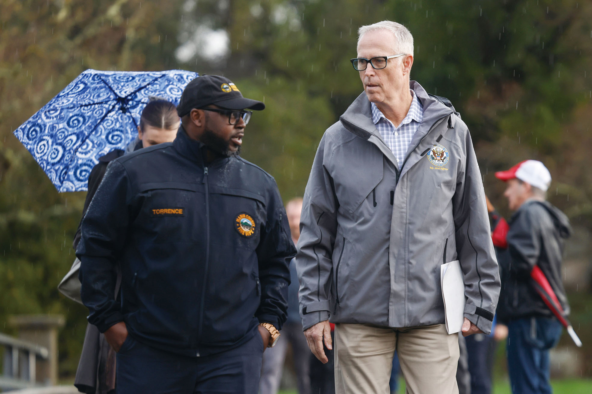 代表聖拉斐的民主黨國會眾議員霍夫曼（右）在麥林縣南部康蒂麥地拉（Corte Madera）了解災情，聽取麥林縣緊急事務局局長介紹。Jessica Christian/三藩市紀事報/美聯社