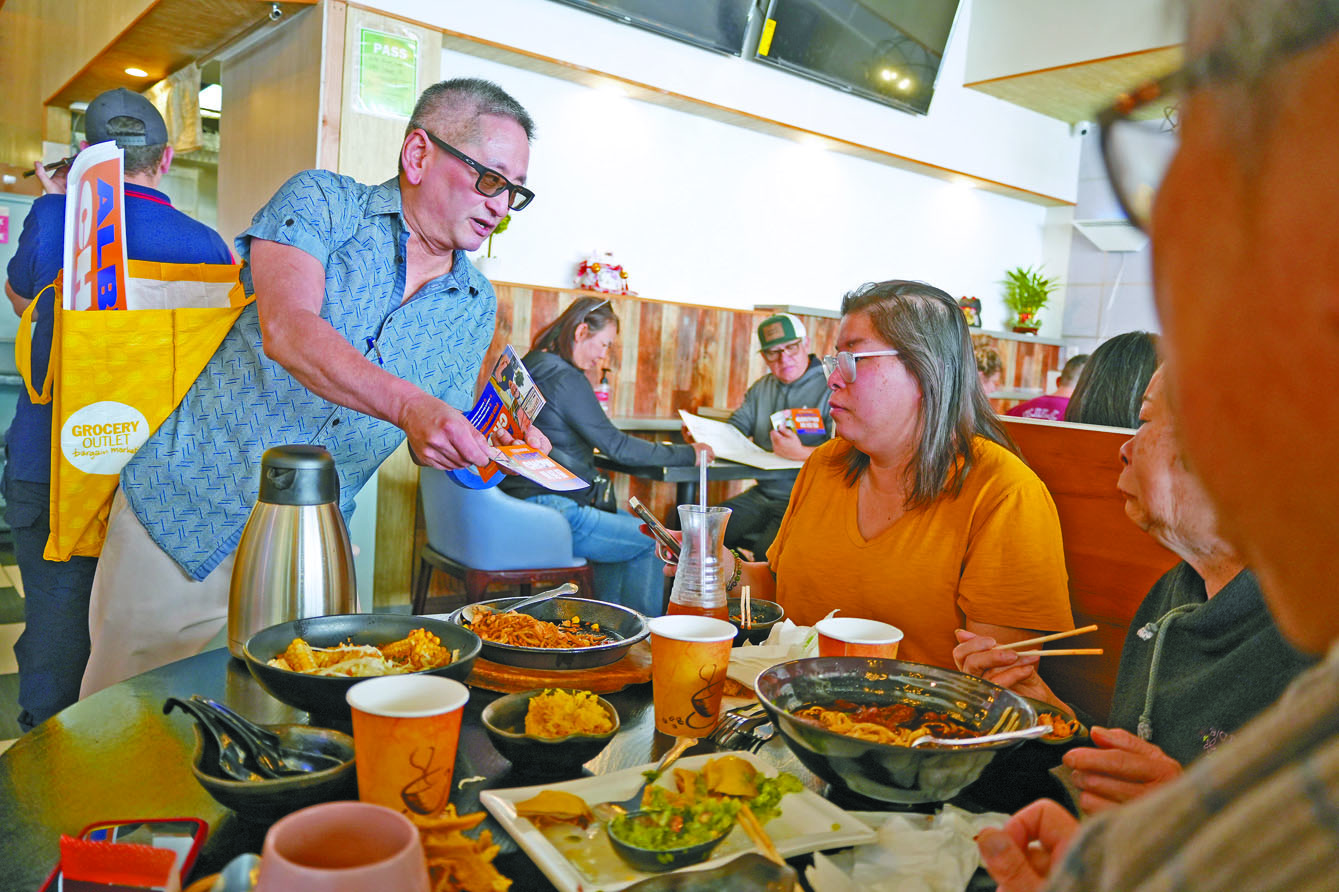 周紹鋆（左）在日落區餐館向顧客自我介紹。記者黃偉江攝