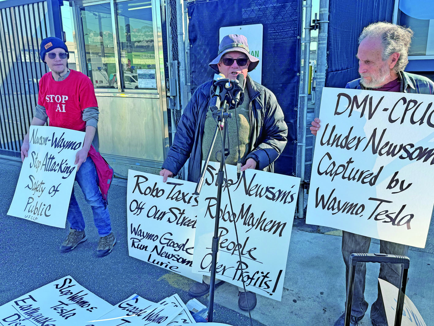 抗議者高舉標語，呼籲暫停Waymo無人駕駛計程車上路。記者陳程威攝