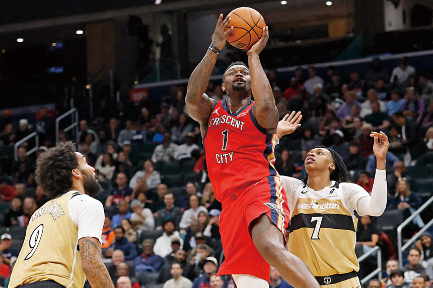 鵜鶘隊前鋒錫安（中）突破奇才球員夾擊投籃得分。路透社