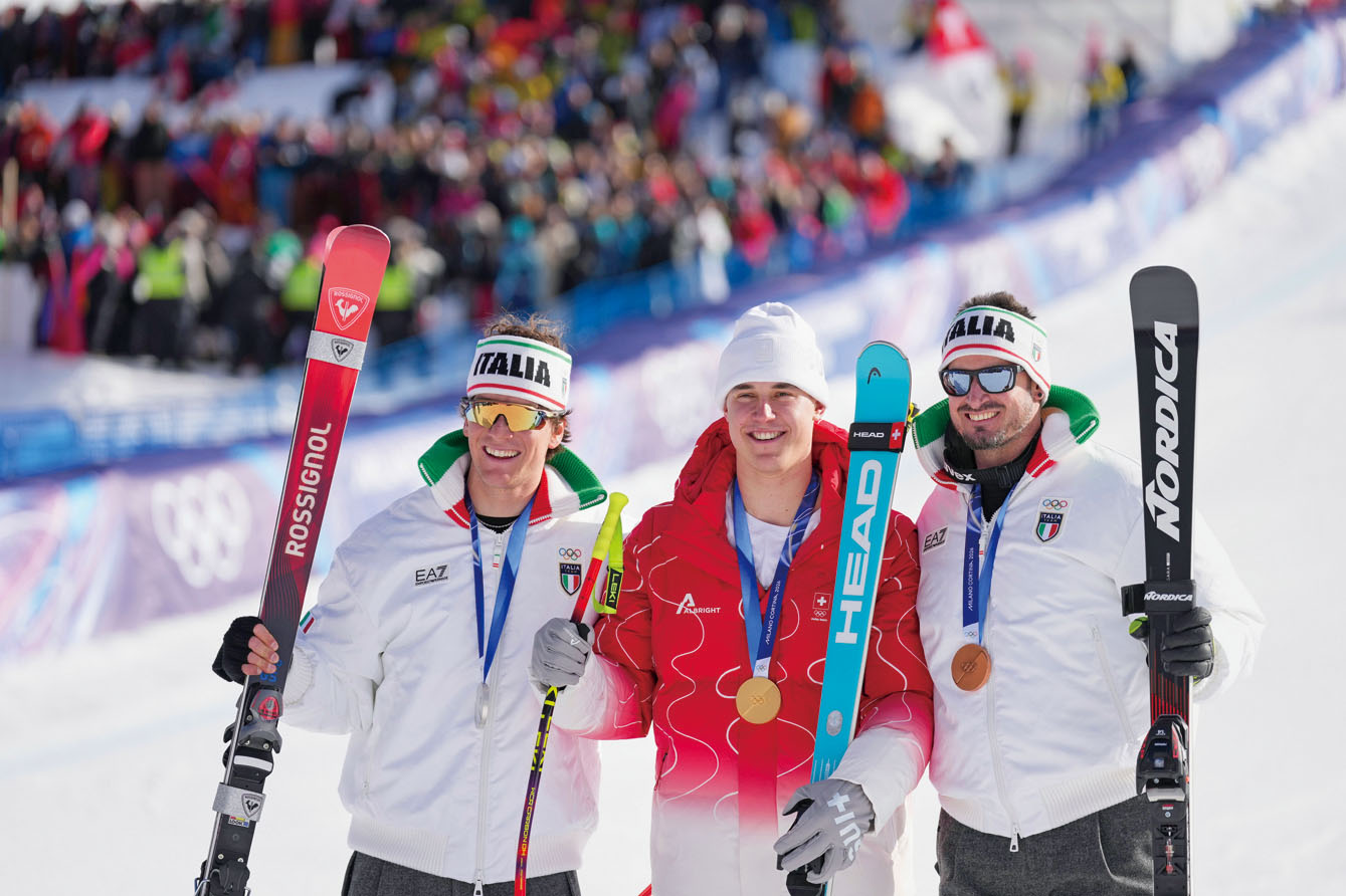 瑞士高山滑雪男子速降金牌得主馮阿爾曼（中）與銀牌及銅牌得主、兩名意大利選手一起慶祝。美聯社