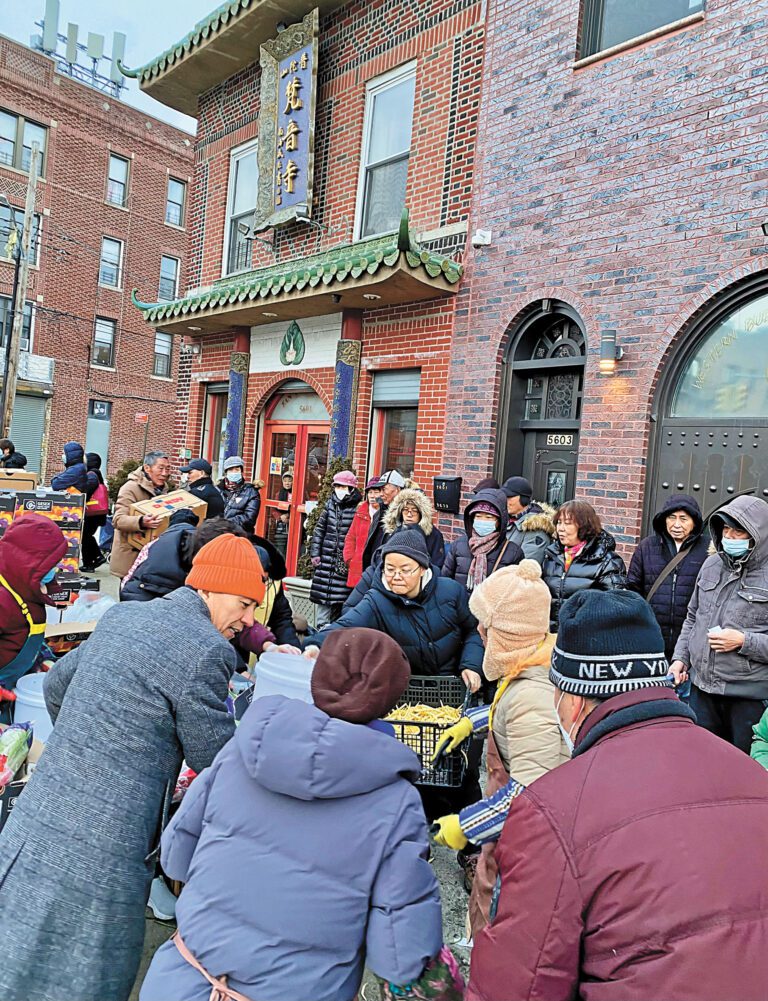 賀立寧(左二)等主辦方代表6日為民眾派發食物。 普陀山紐約梵音寺提供