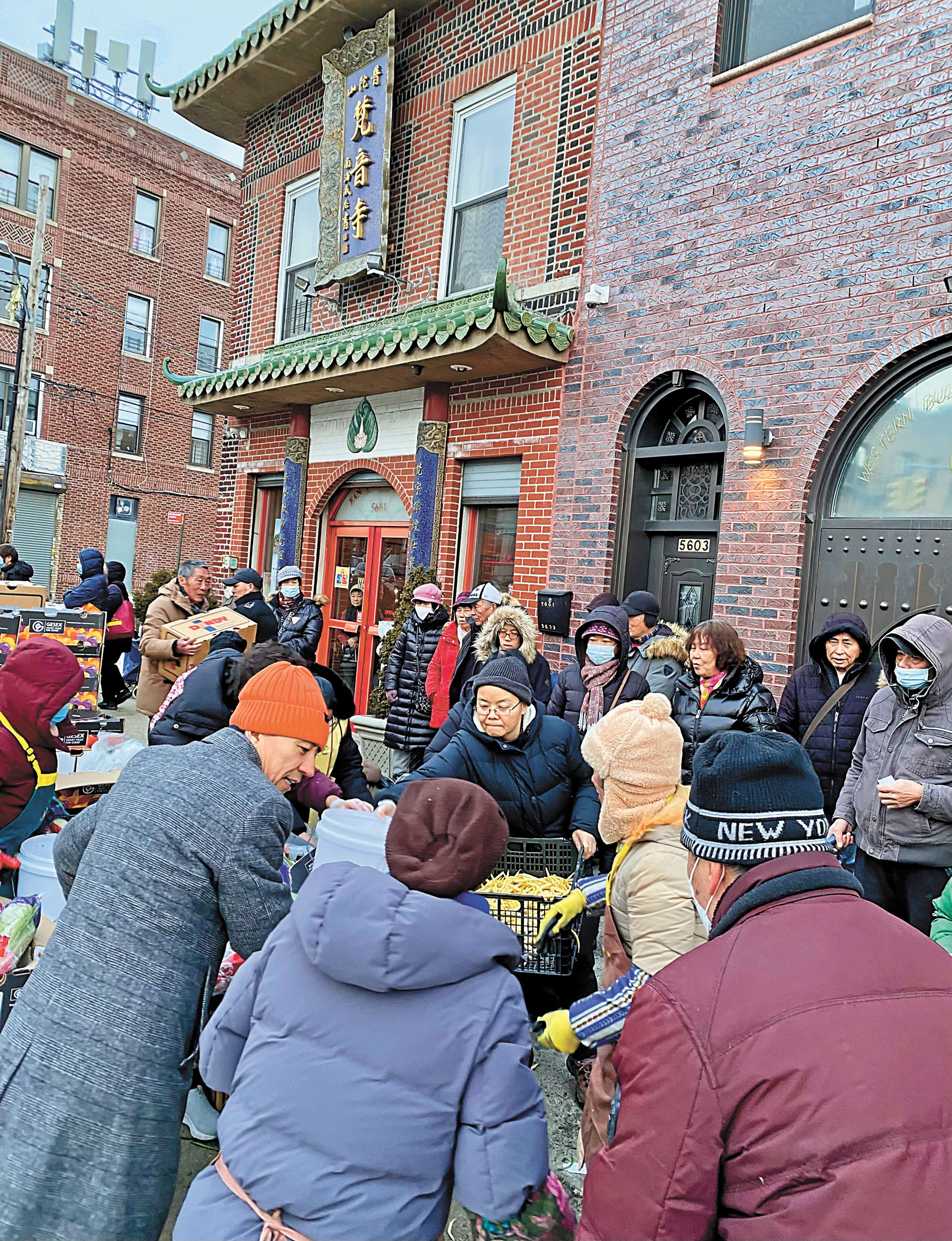 賀立寧(左二)等主辦方代表6日為民眾派發食物。 普陀山紐約梵音寺提供