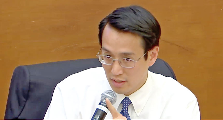 衛生局局長蔡維衡(Daniel Tsai)出席健康委員會聽證會，說明2026-27年度預算削減方向。視頻會議截圖